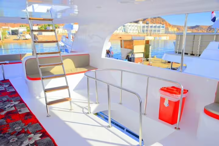 Boat deck with ladder and sunlit seating before Marsa Mubarak snorkeling tour in Marsa Alam to see dugongs