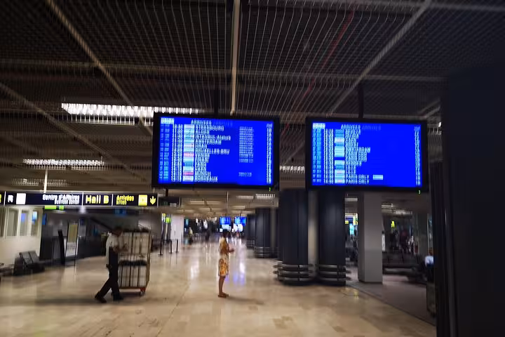 Marseille Provence Airport arrivals hall with flight information screens, meeting point for cruise port minivan transfer