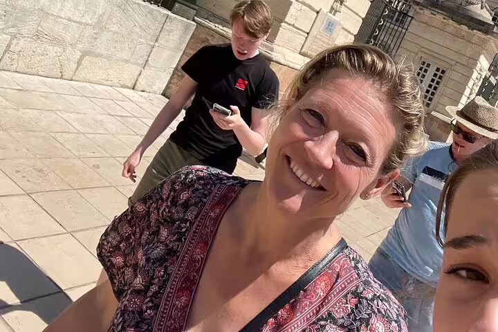 Smiling participants on a Marseille e-scavenger hunt, using phones for a self-guided city puzzle tour