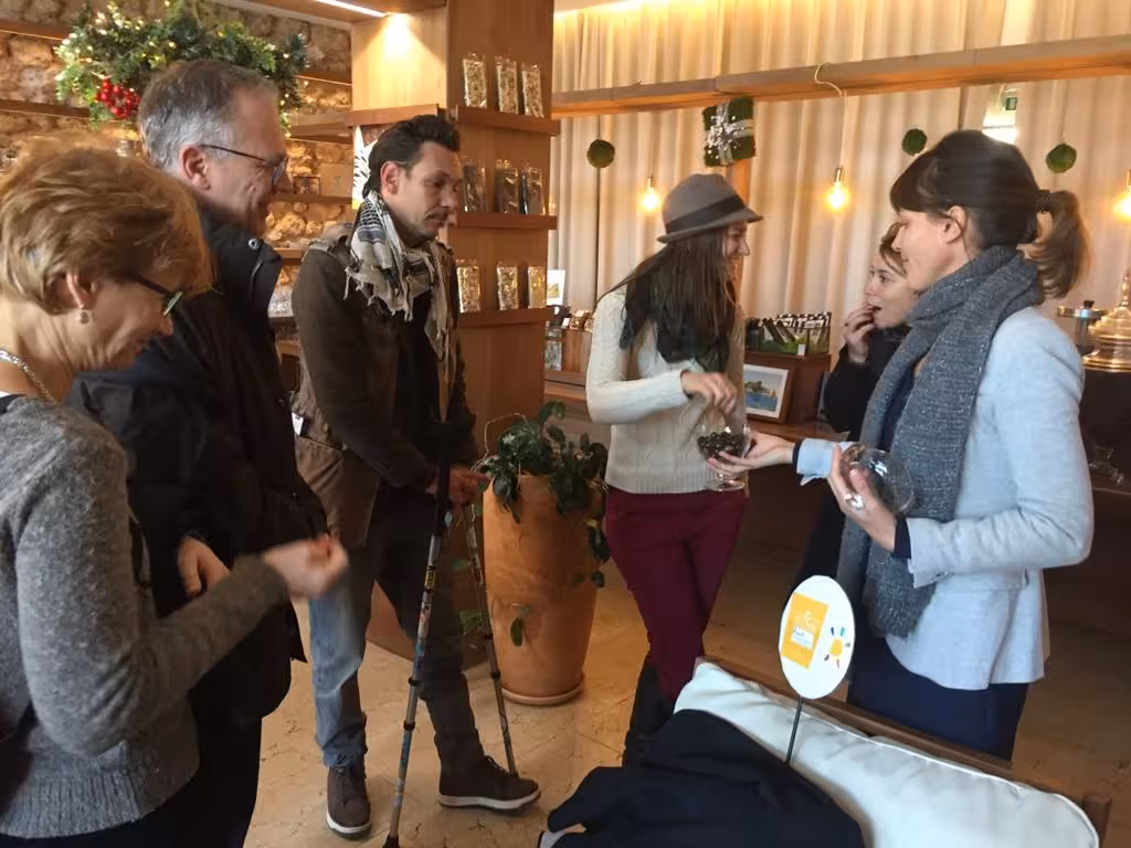 Small group sampling artisan treats inside a Marseille delicatessen on a guided food tour and tasting experience