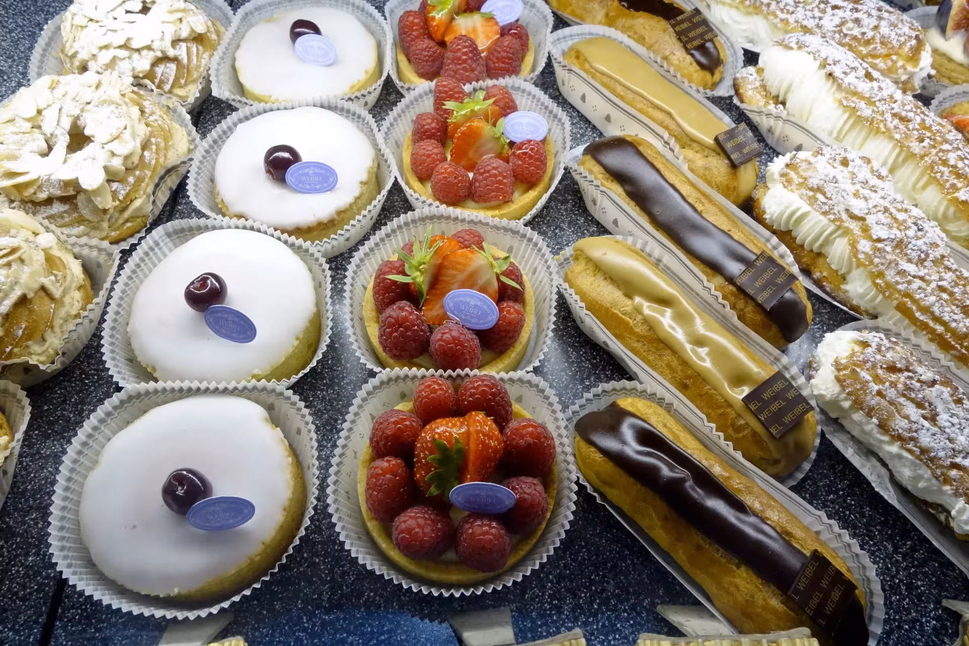 French pastry tasting on Marseille food tour with éclairs, raspberry tarts and almond cakes in a bakery display