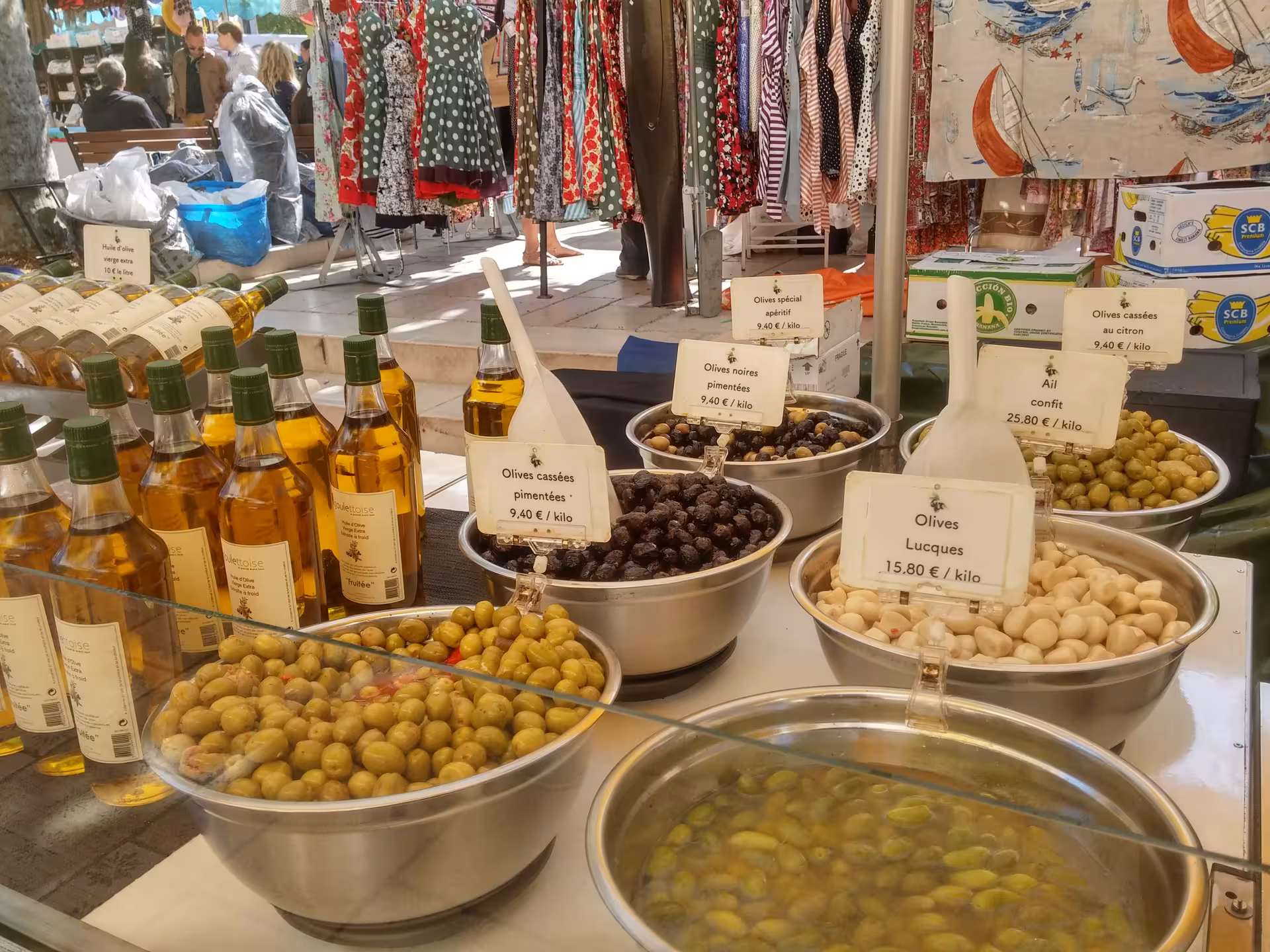 Marseille food tour stop at Provençal market olive stall with tapenade, garlic confit and olive oil bottles