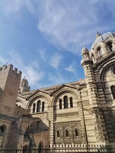 Marseille old district landmark, striped stone cathedral facade on the street art, craft and wine walking tour