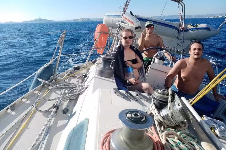 Guests relax on a sailboat off Marseille, Provence, enjoying windy sea views on a small-group sailing tour