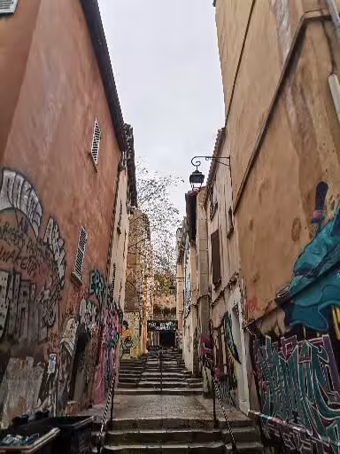 Graffiti-lined staircase alley in Marseille old district, a highlight on the street art and craft wine tour