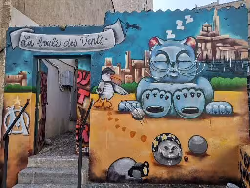 Colorful street art mural in Marseille old district, a playful cat and cityscape on the craft & wine tour