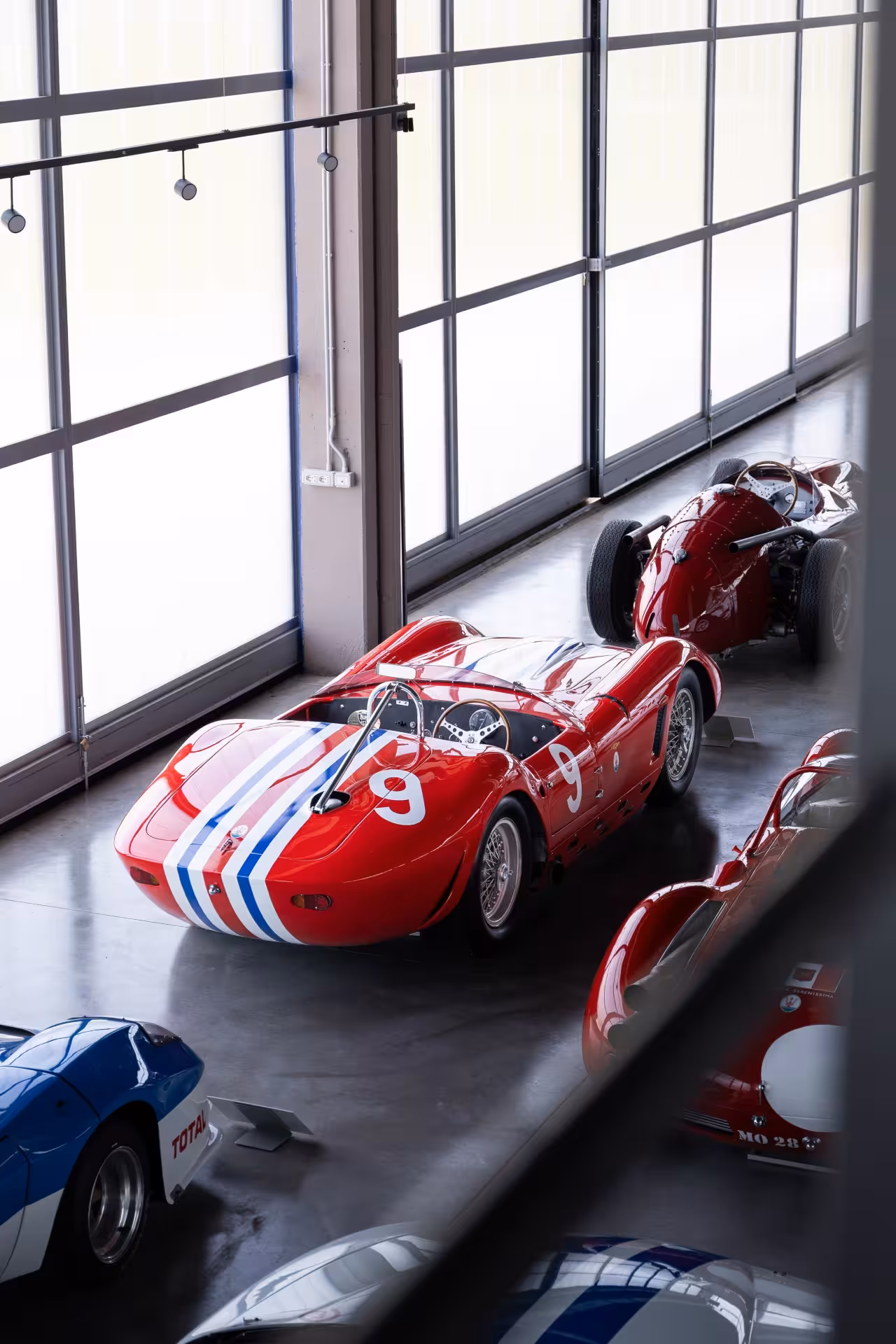 Red vintage Maserati race car on display at Umberto Panini Collection museum in Modena, Italy entrance ticket
