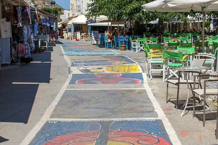 Vibrant street art and bustling cafes in Matala, Crete, offering a lively atmosphere for visitors exploring local culture.