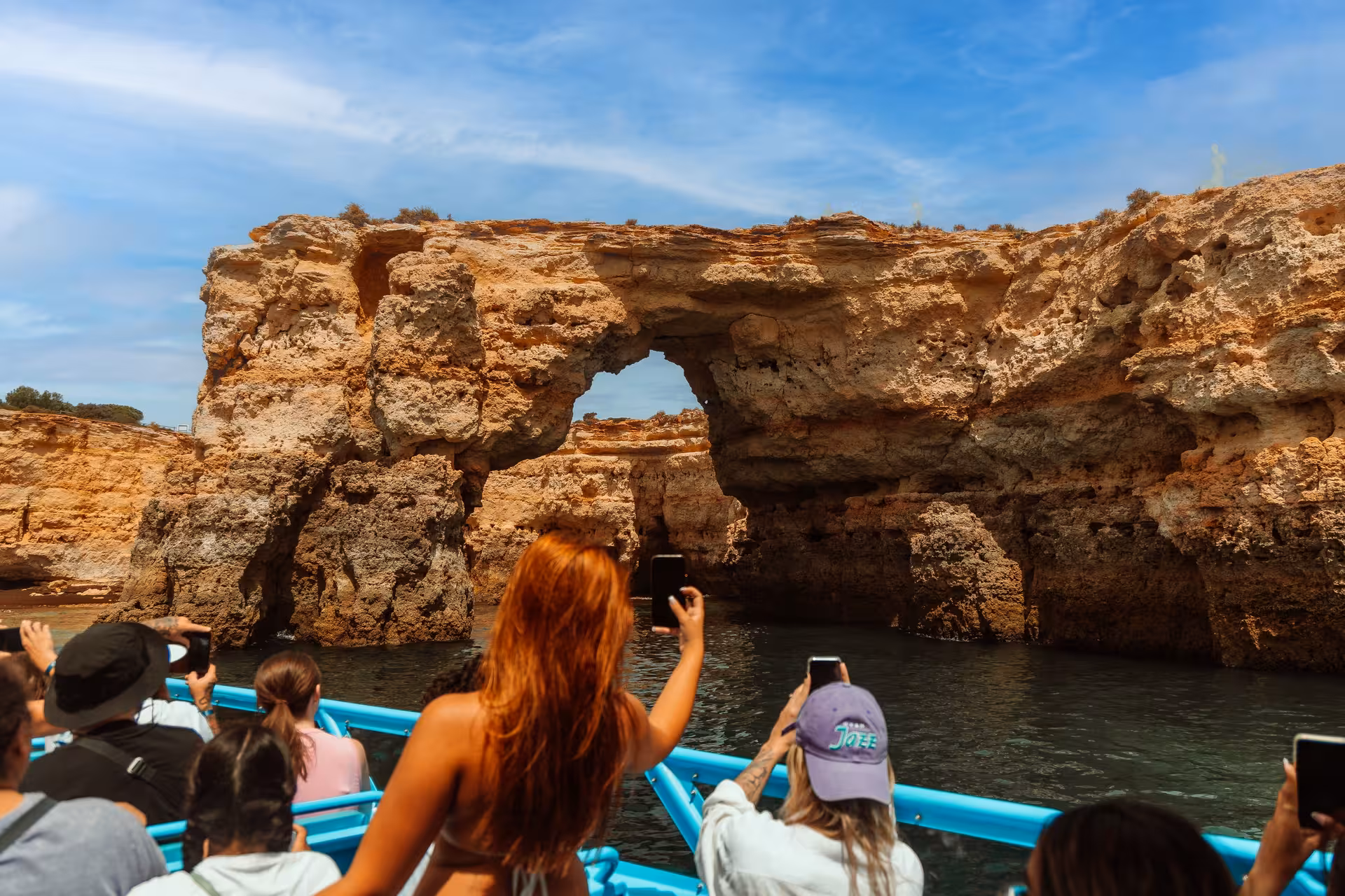 Tourists capture stunning rock formations and caves on a MATRIX boat tour, highlighting natural wonders.