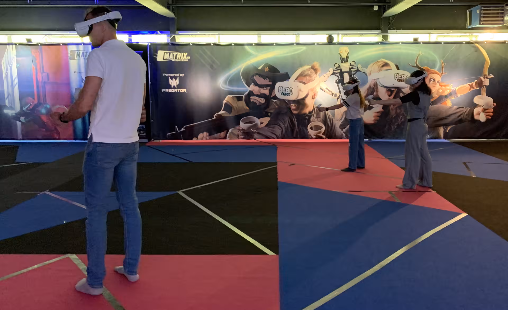 Guests wearing VR headsets in Matrix X free-roam arena, immersive virtual reality action experience indoors