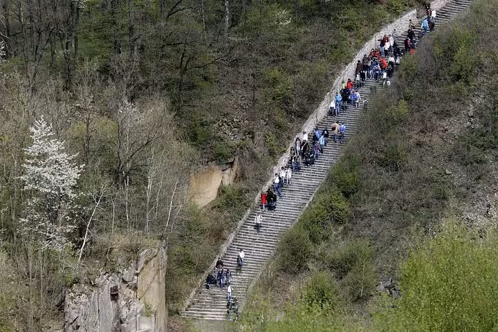 Visitors climb the long quarry stairs at Mauthausen Memorial on a private day trip from Vienna, Austria