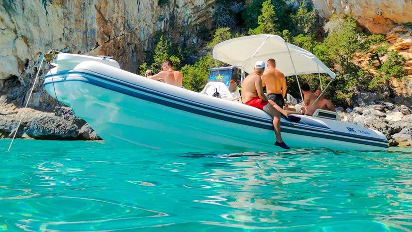 Group enjoying a Maxi dinghy ride in the Gulf of Orosei, surrounded by stunning cliffs and crystal-clear waters.