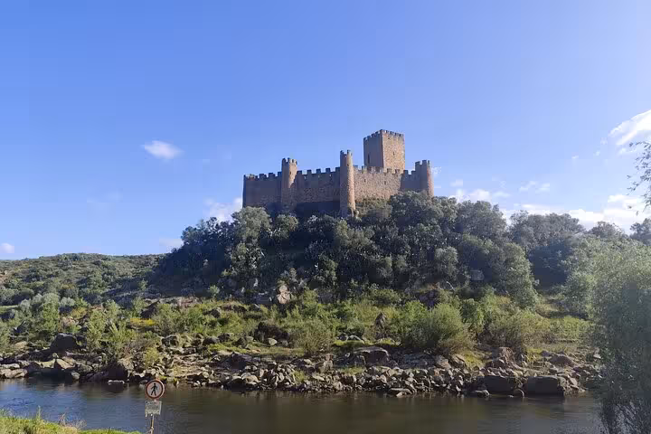 Medieval castle on a hill above a river, historic sightseeing stop on Lisbon Porto or Porto Lisbon transfer