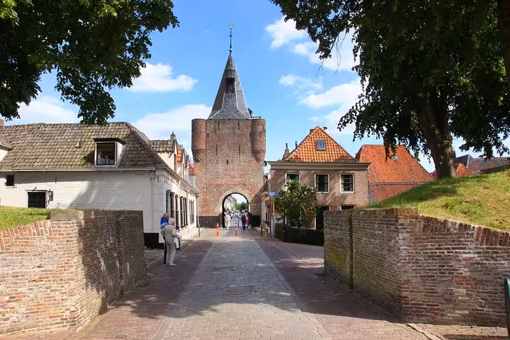 Medieval brick gate tower and cobbled street in a Dutch village on Discover The Netherlands tour from Amsterdam
