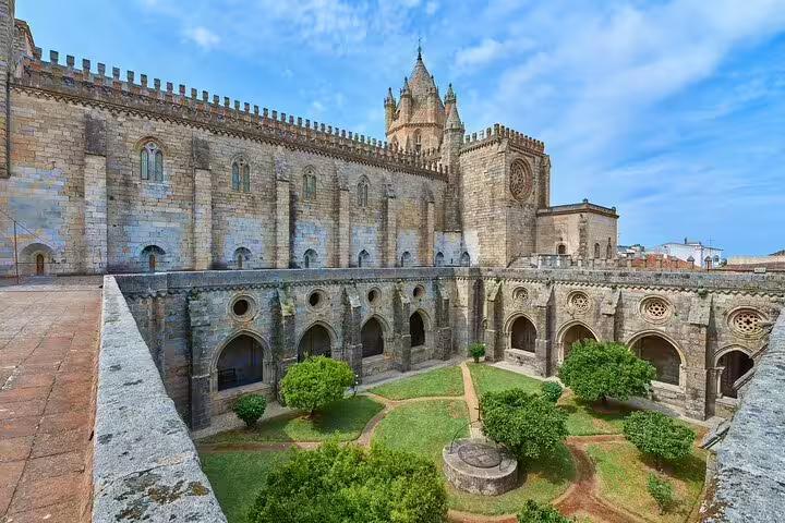 Explore the stunning medieval architecture of Évora's iconic cathedral courtyard on a private full-day historical tour.