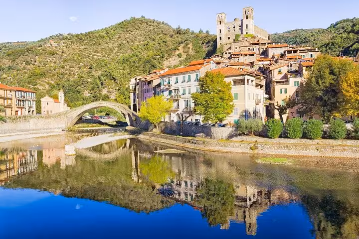 Medieval Italian village with arched stone bridge and hills, perfect for Riviera private tour exploration.