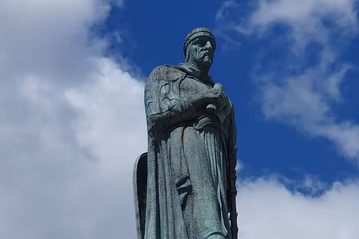 Statue of a medieval knight under a bright blue sky in Tomar, Portugal, symbolizing the city's rich history.