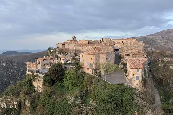 Aerial view of a medieval village perched on a cliff in the picturesque Provencal countryside.
