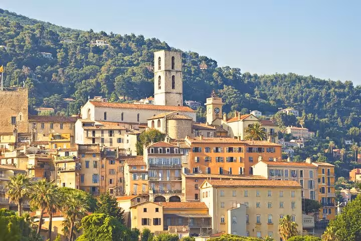 Charming medieval village with a prominent church tower nestled in the green hills of Provence.
