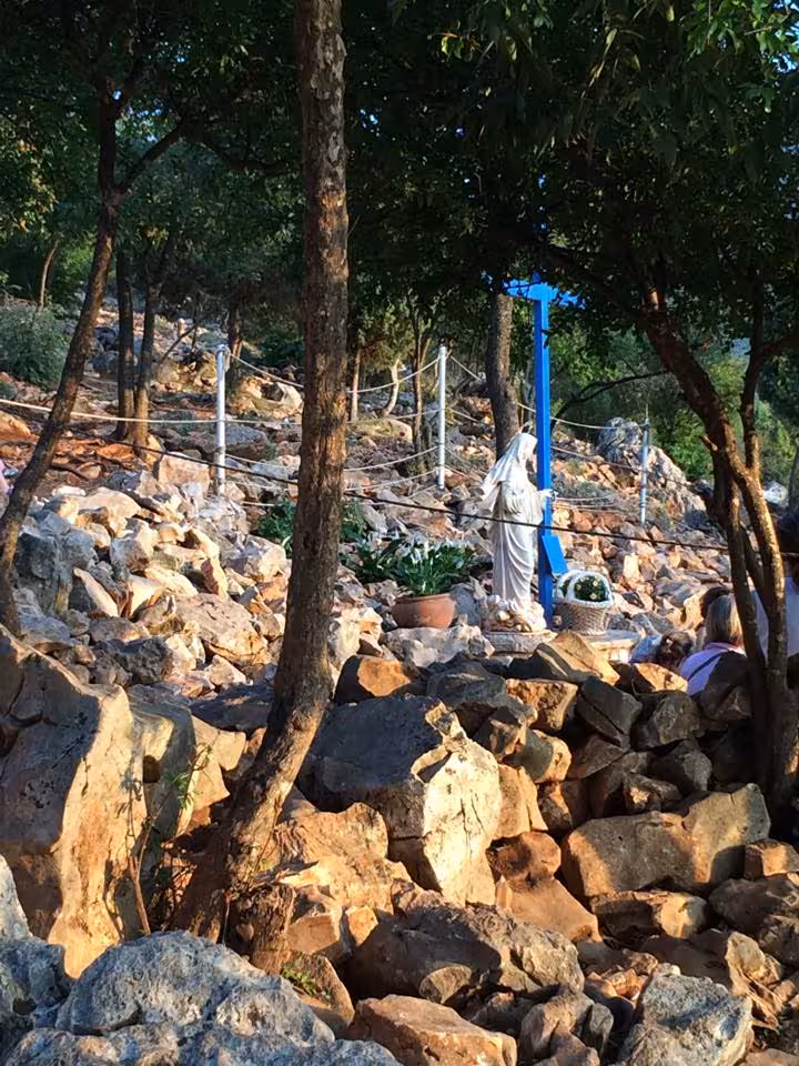 Rocky Apparition Hill in Medjugorje with Virgin Mary statue and cross, spiritual hike on Split day tour