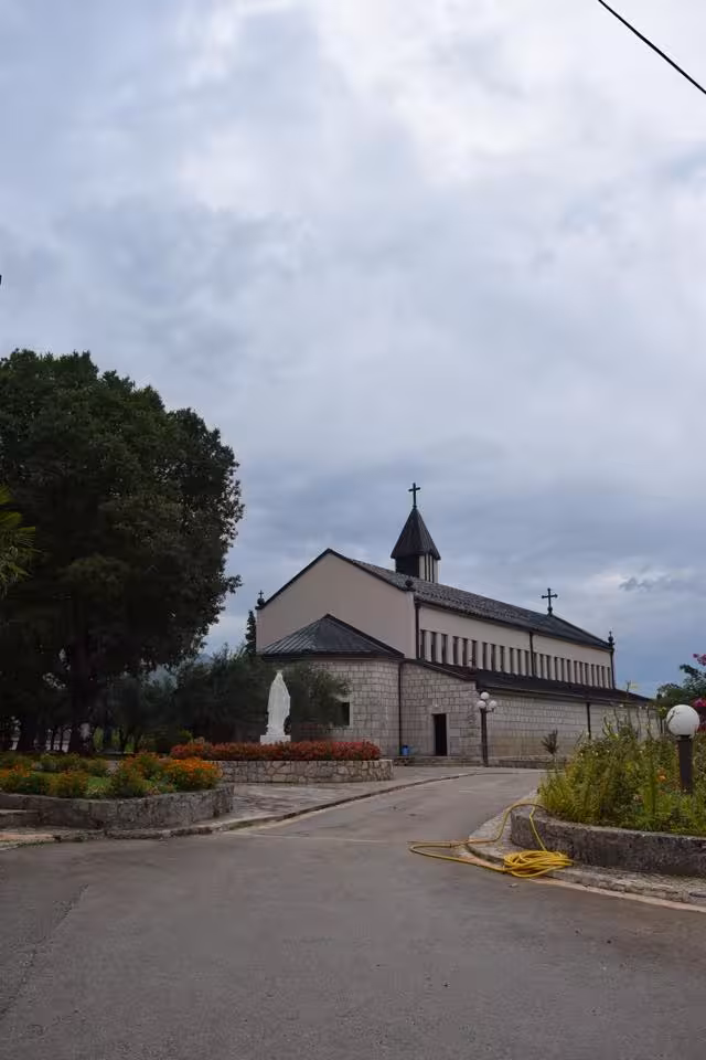 Medjugorje parish church exterior on day trip from Split, Bosnia pilgrimage stop with peaceful gardens