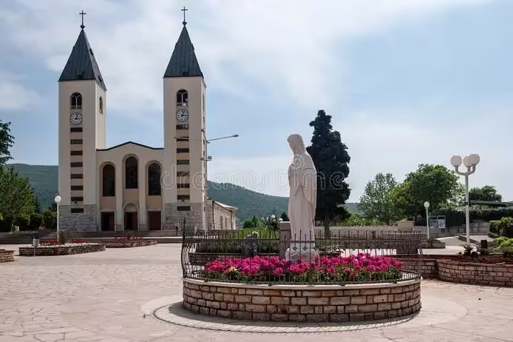 Medjugorje St James Church and Virgin Mary statue in flowered plaza, key stop on private tour Bosnia
