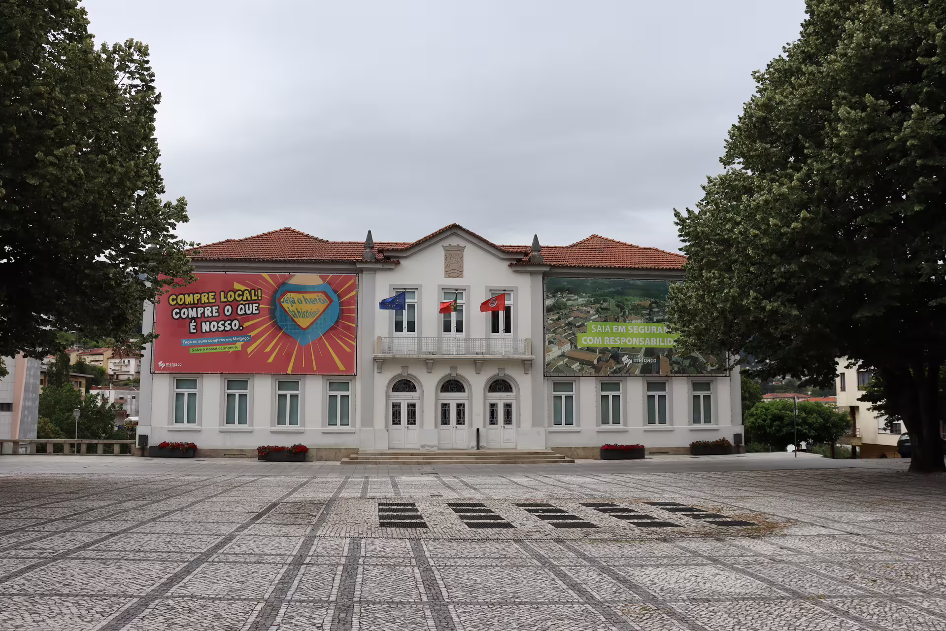 Historic building in Melgaço town square, adorned with local banners, on the Private Tour to the Alvarinho wine region.