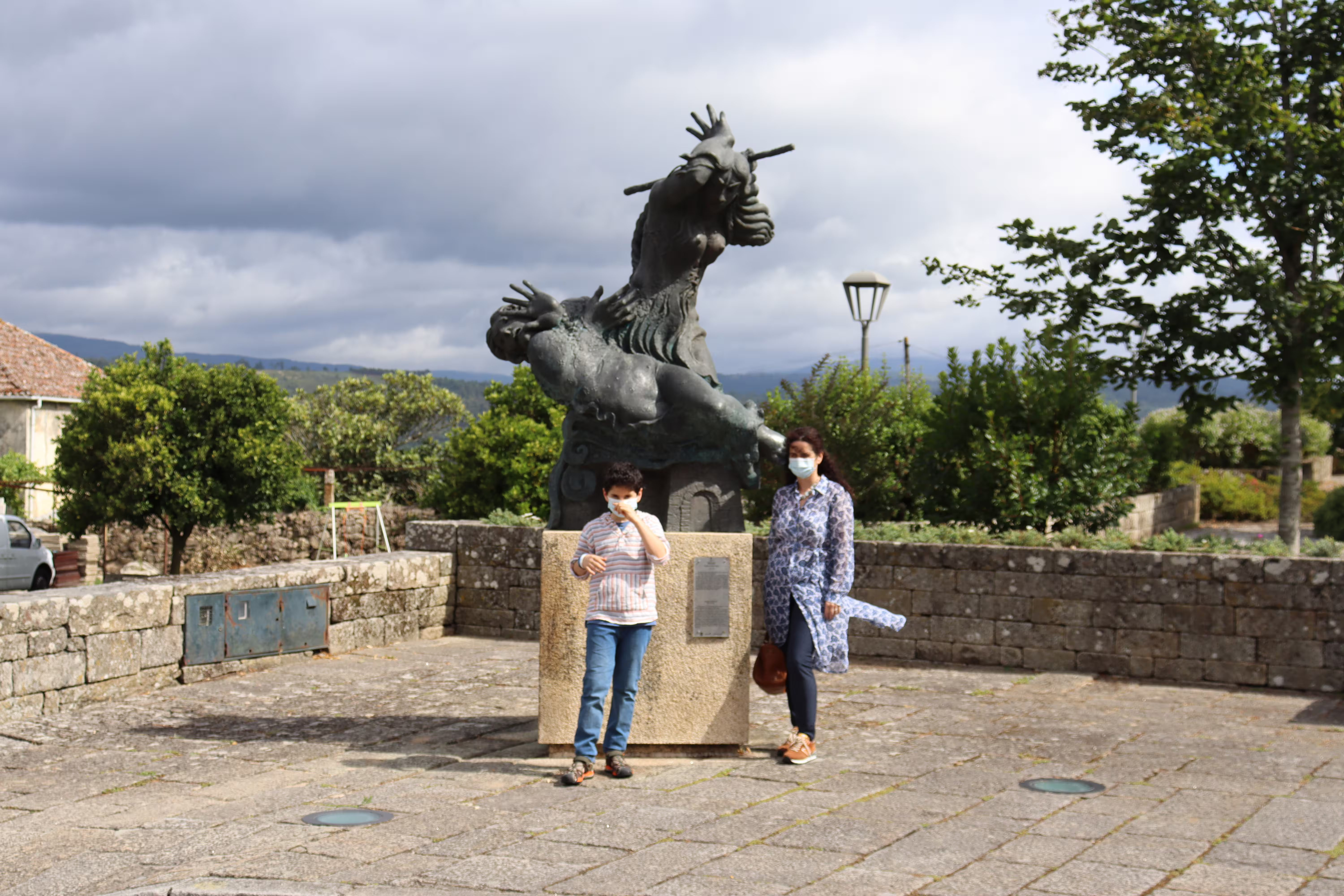Visitors in front of a unique sculpture in a scenic spot in Melgaço, Portugal, embodying the charm of the Alvarinho wine region.