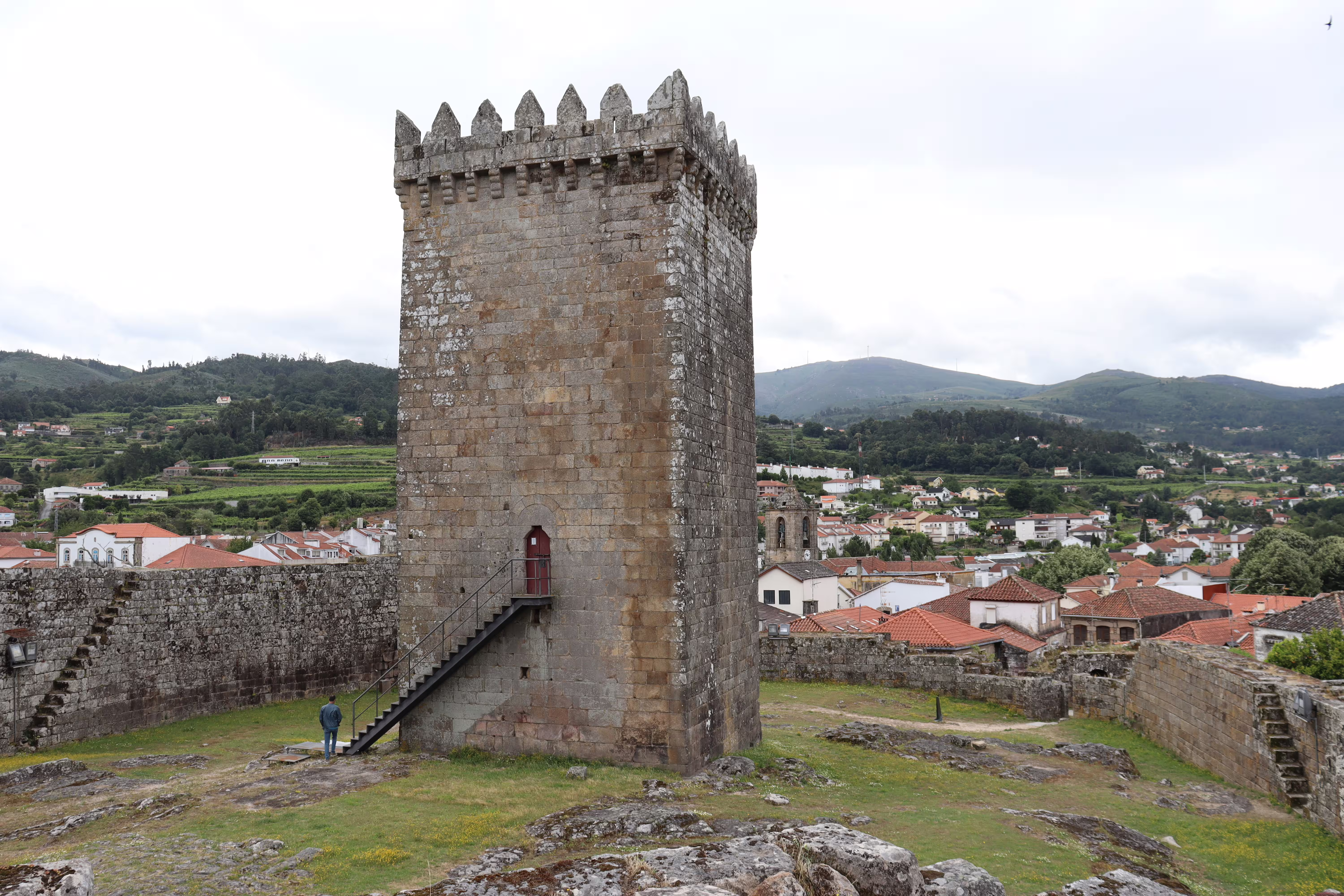 Ancient stone tower in Melgaço overlooking scenic vineyards and village, highlighting the charm of Portugal's Alvarinho region.