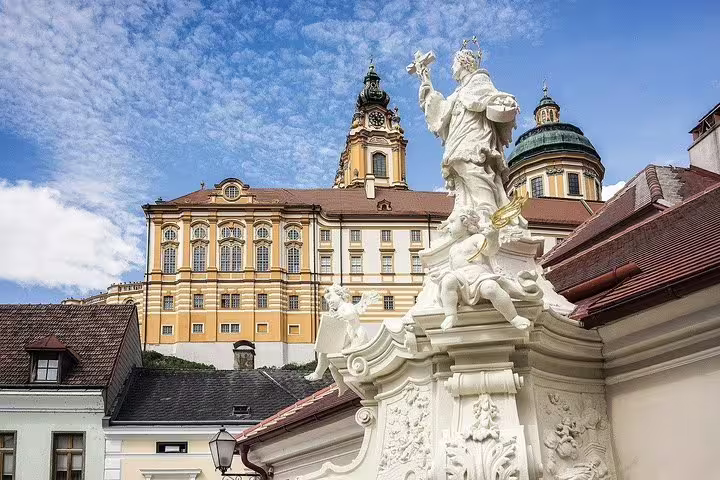 Melk Abbey courtyard statue and baroque towers, highlight stop on private Wachau Valley day trip from Vienna