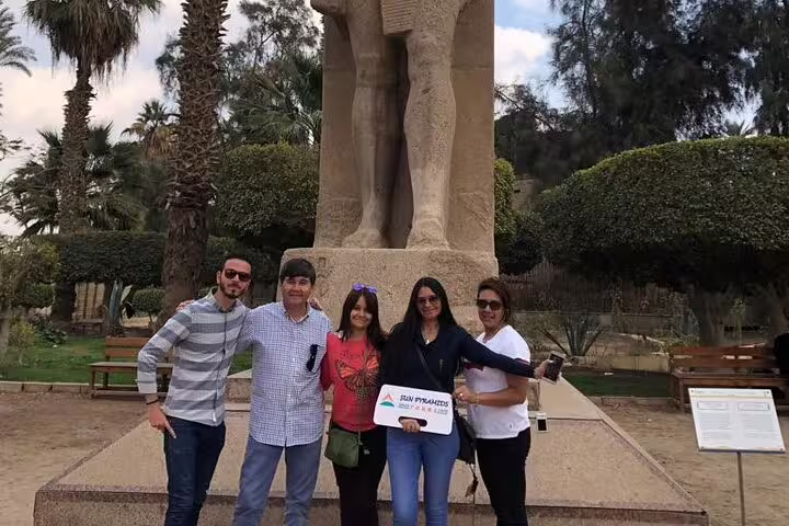 Travelers at Memphis open-air museum by colossal Ramses II statue on Sakkara Dahshur private tour
