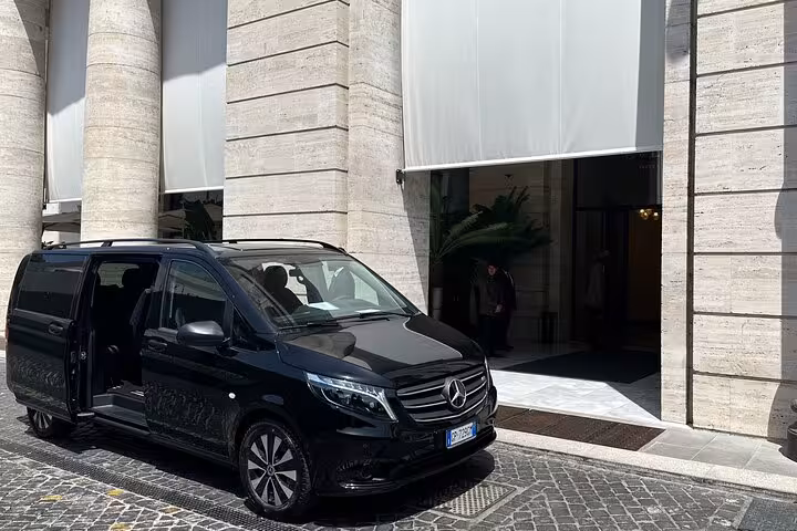 Mercedes van stationed outside a hotel, highlighting private transfer service from Amalfi Coast to Rome in elegance.