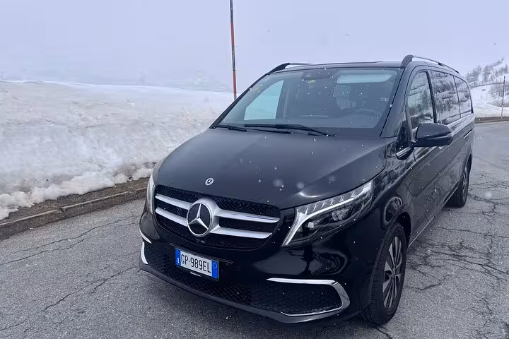 Luxurious black Mercedes van parked on a charming cobblestone street in Milan, ideal for MXP airport transfers.