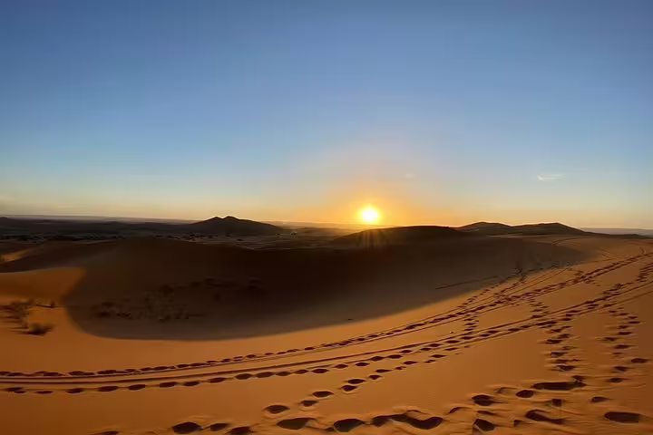 Sunrise over Merzouga Sahara dunes with footprints, highlight of Morocco 12 days tour from Tangier