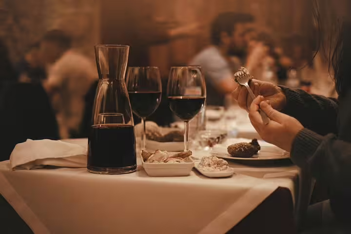 Close-up of a dining table with wine and traditional Portuguese dishes at Mesa de Frades, enhancing the Fado experience.