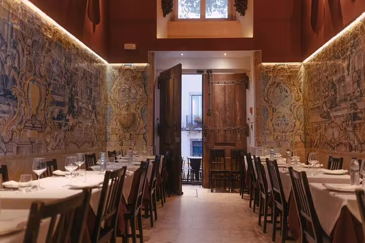 Elegant dining area at Mesa de Frades in Lisbon, featuring traditional Portuguese azulejo tiles and intimate ambiance.