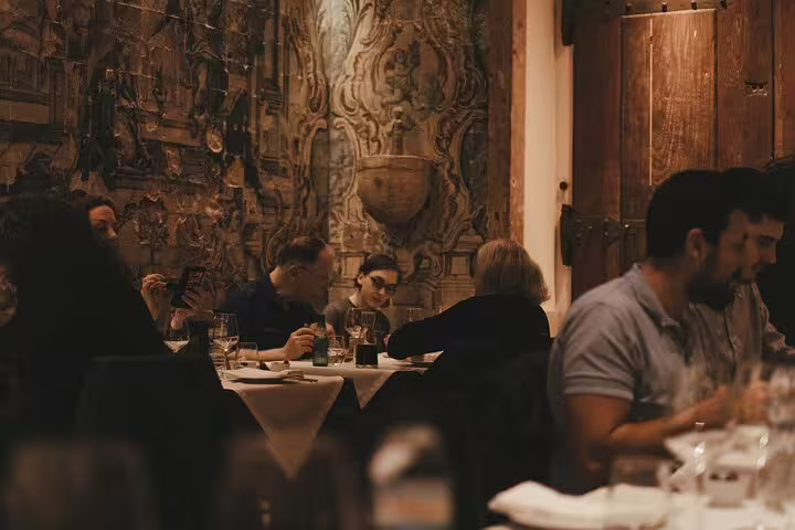 Guests enjoying a cozy dinner at Mesa de Frades in Lisbon, surrounded by traditional Portuguese decor.