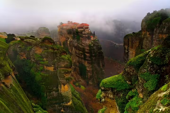 Meteora monastery perched on misty rock pillars, scenic stop on a full-day private tour from Athens