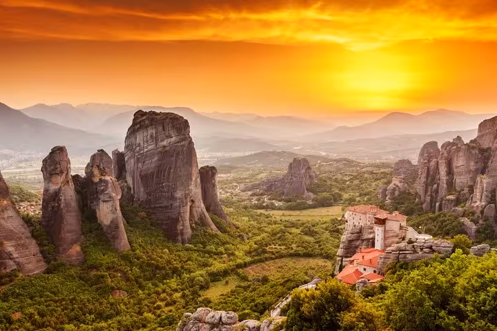 Sunset view over Meteora rock pillars and clifftop monastery, highlight of a 2-day luxury private trip from Athens