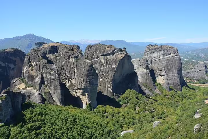 Majestic Meteora rock formations under clear blue skies during a 4-day classical private tour from Athens.