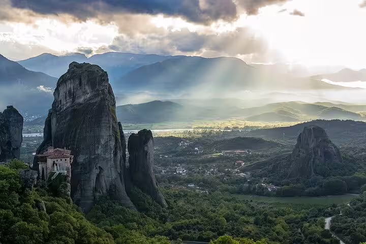Sunbeams over Meteora rock formations and valley view on Delphi and Meteora private day trip from Athens