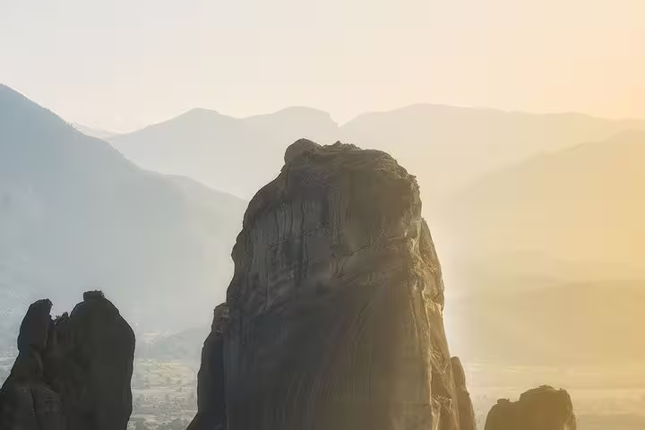 Sunrise over a towering Meteora sandstone pillar, scenic stop on the Delphi & Meteora two-day tour