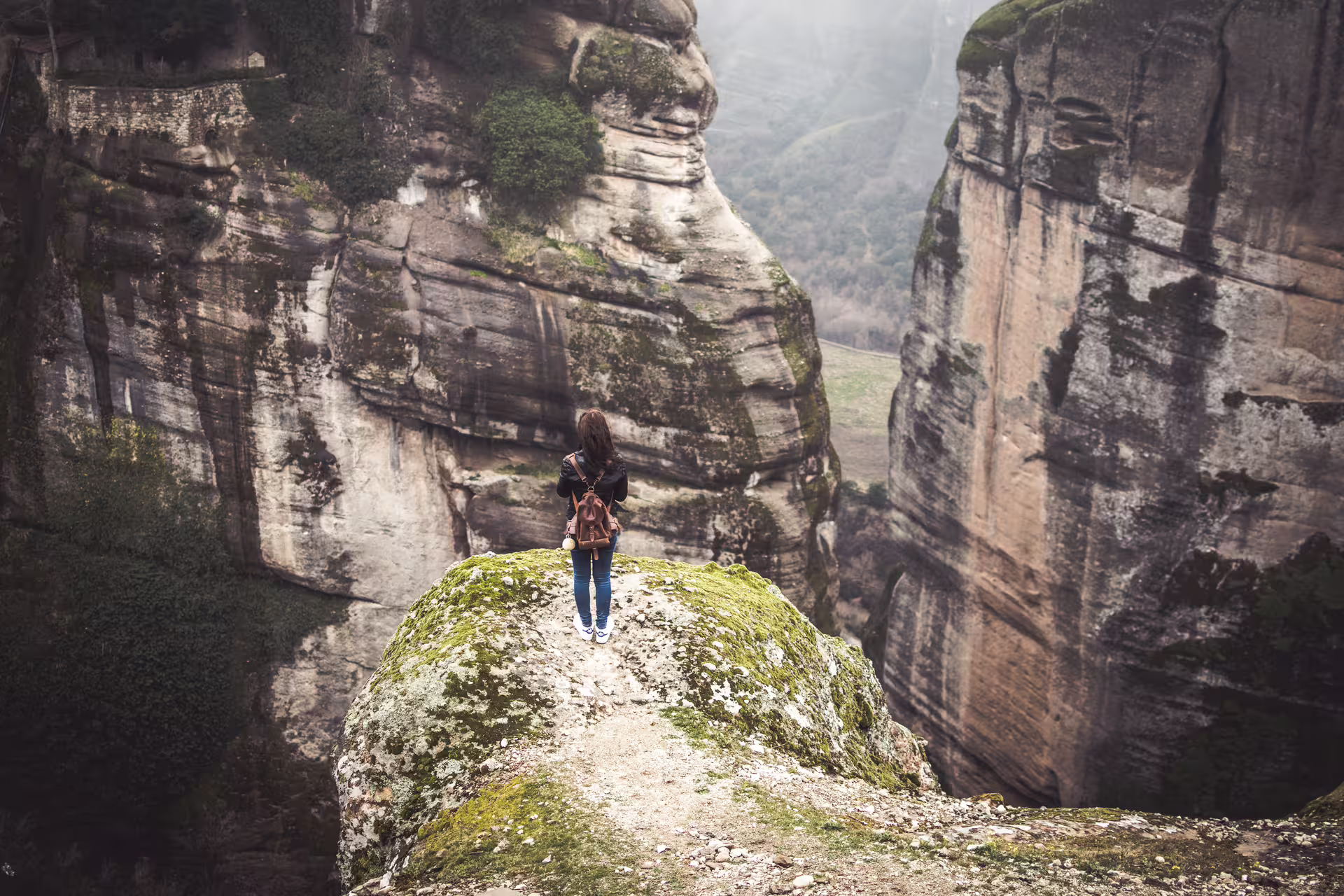 Traveler on Meteora rock viewpoint during 2-day private Athens to Meteora tour with overnight in Kastraki
