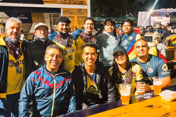 Group of locals in Club América colors with beers outside Mexico City stadium on soccer matchday tour
