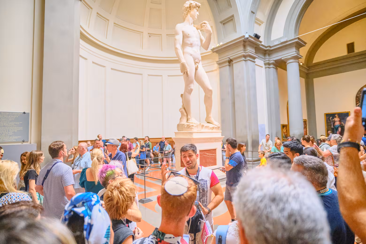 Tourists admire Michelangelo's David during a guided Accademia Gallery tour in Florence.