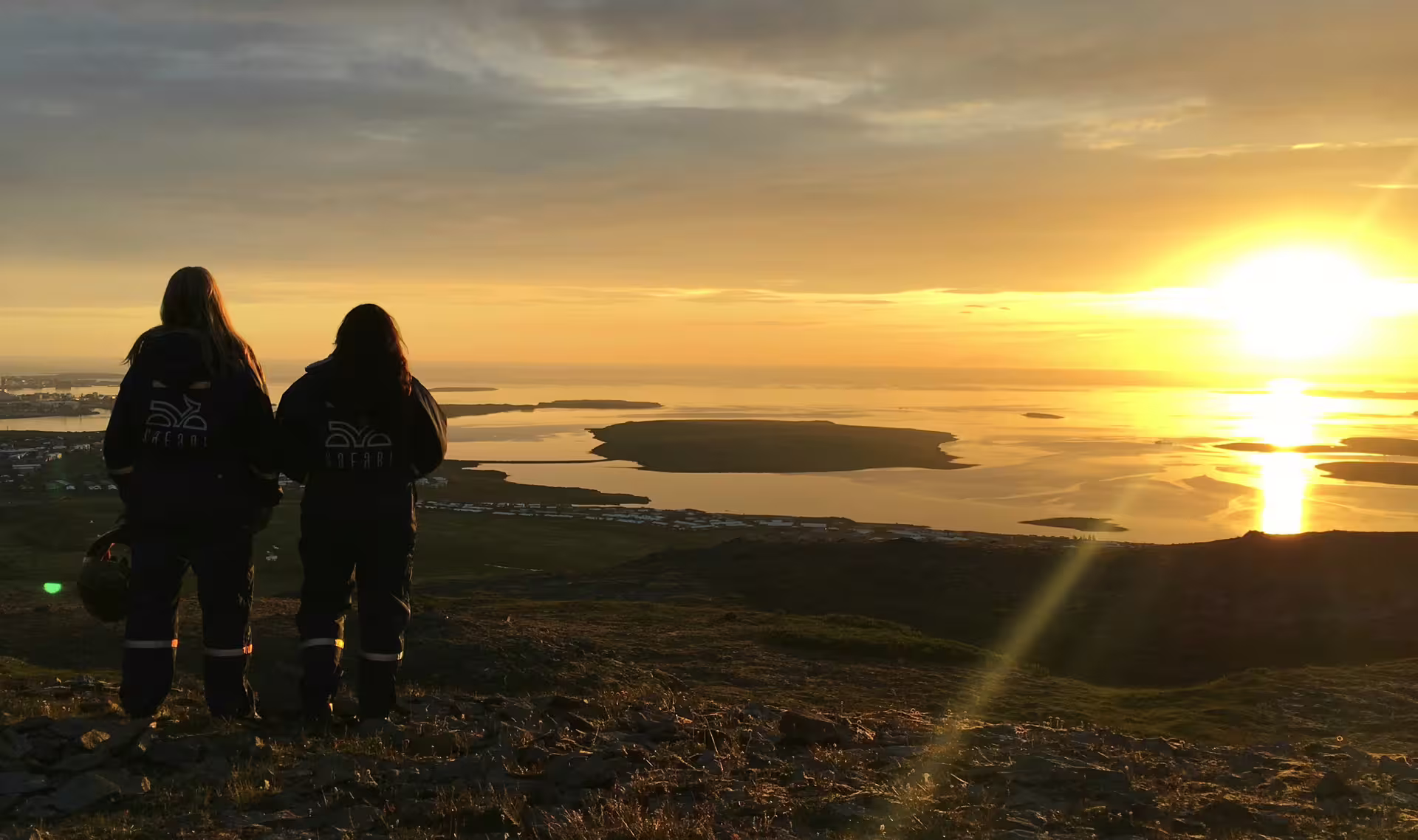 Adventurers enjoy a breathtaking view of the midnight sun over a serene landscape during a 2-hour ATV tour.