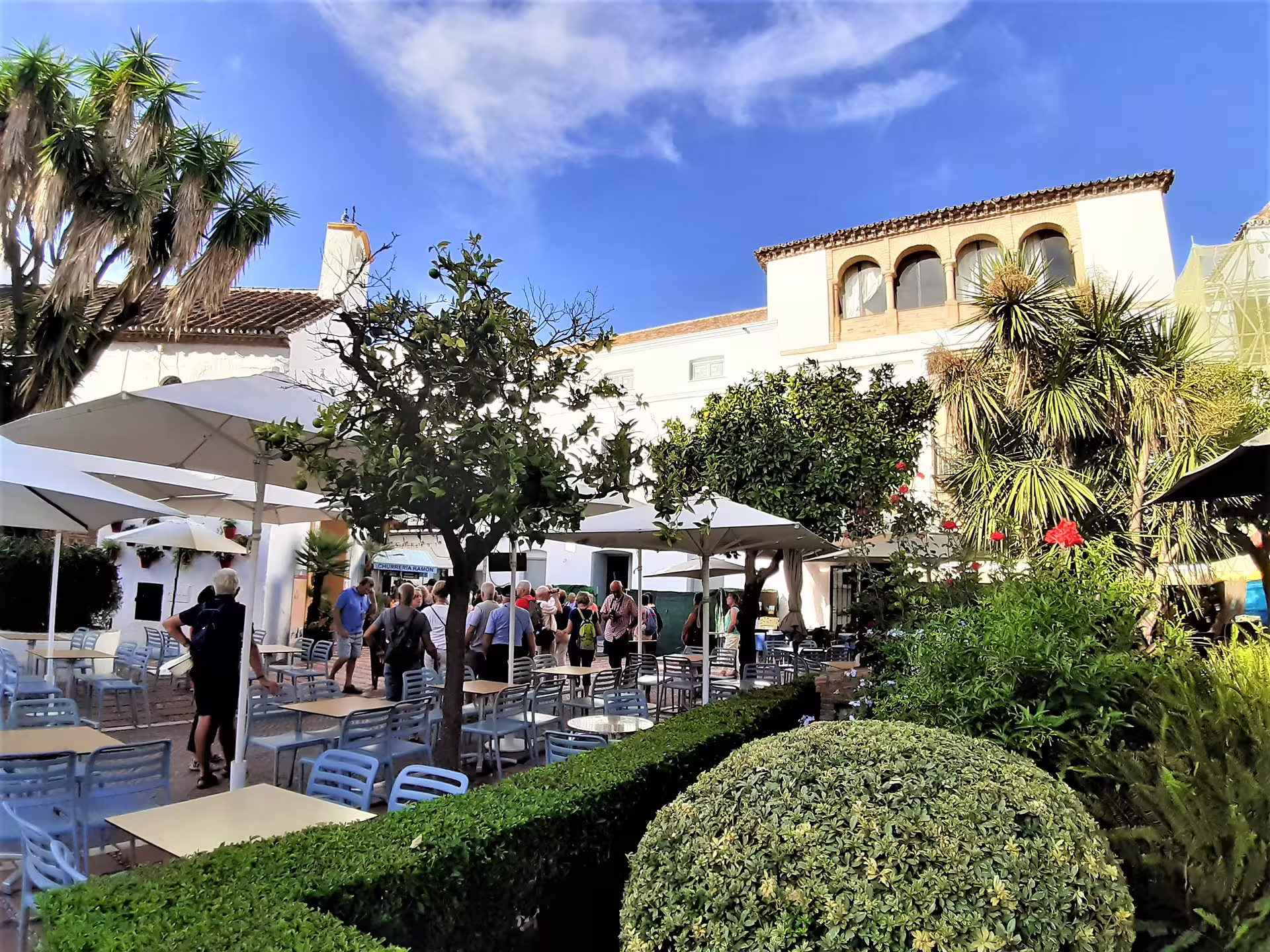 Outdoor terrace in Mijas Pueblo with umbrellas and gardens, part of Mijas Marbella Puerto Banus group day trip