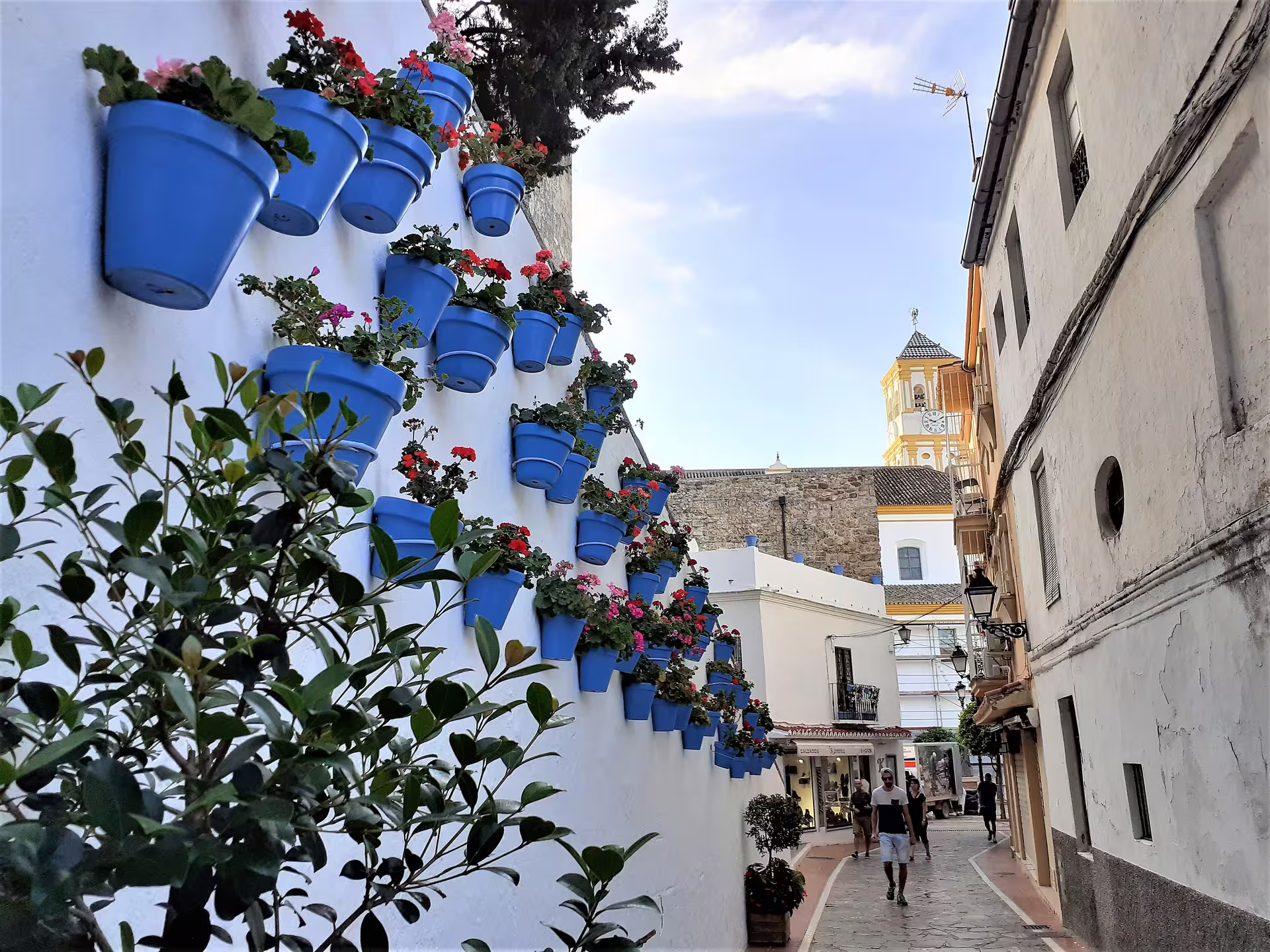 Mijas Pueblo whitewashed alley with blue flower pots, a highlight on Costa del Sol day trip from Malaga