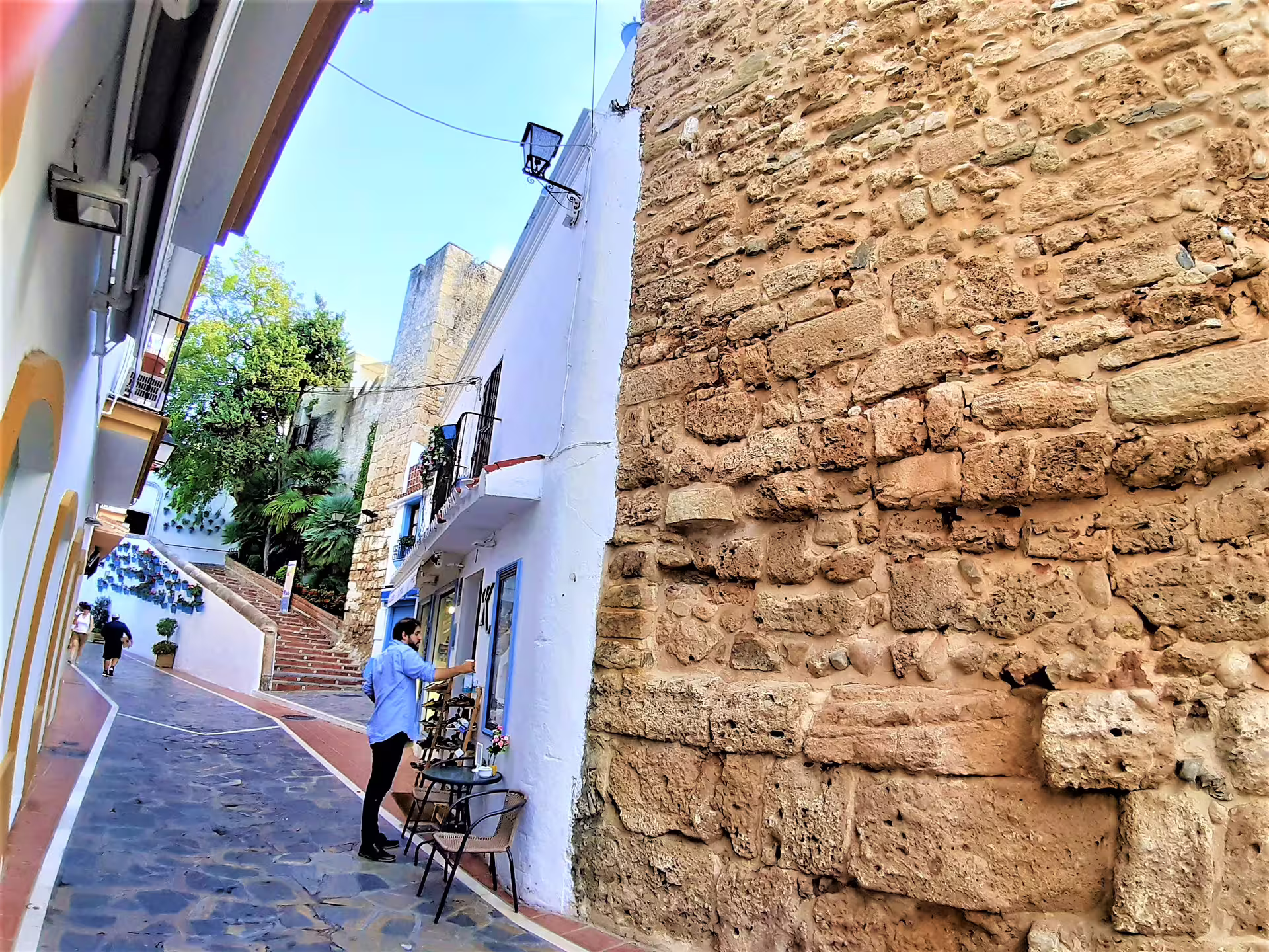 Charming whitewashed alley in Mijas Pueblo on Costa del Sol group tour with pick-up, stone walls and steps