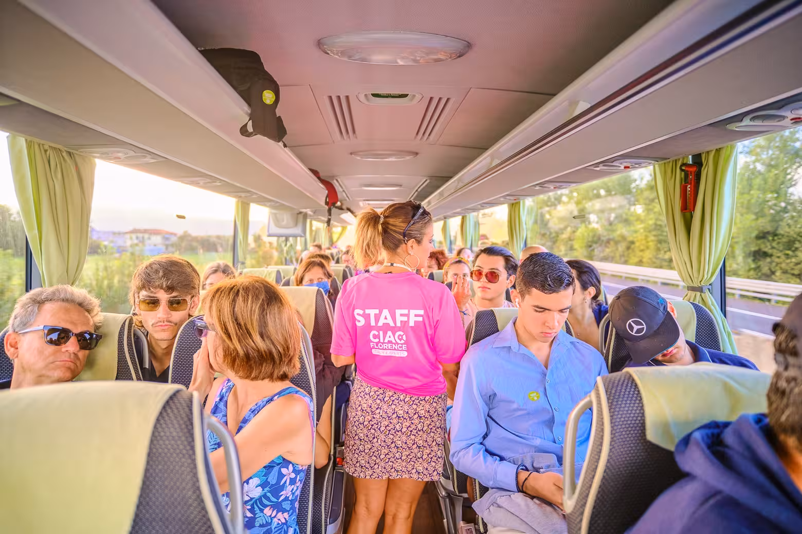 Travelers seated on a comfortable tour bus en route from Milan to Cinque Terre, guided by attentive staff.